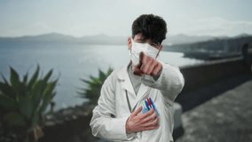 Young man in white coat hugs pens on seaside promenade with plants and calm ocean under clear sky. - Powered by Shutterstock - Get 15% off with code: PIKWIZARD15