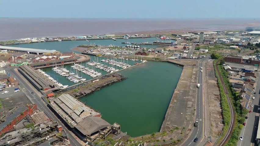 Aerial drone perspective of Grimsby port and docks, with ferrys, private yachts, industrial fishing wharfs and buildings, clock tower on Humber Estuary Lincolnshire fishing town. 