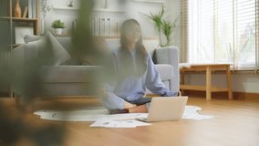 Happy young Asian woman practicing yoga and meditation at home sitting on floor in living room in lotus position and relaxing with closed eyes. Mindful meditation and wellbeing concept - Powered by Shutterstock - Get 15% off with code: PIKWIZARD15