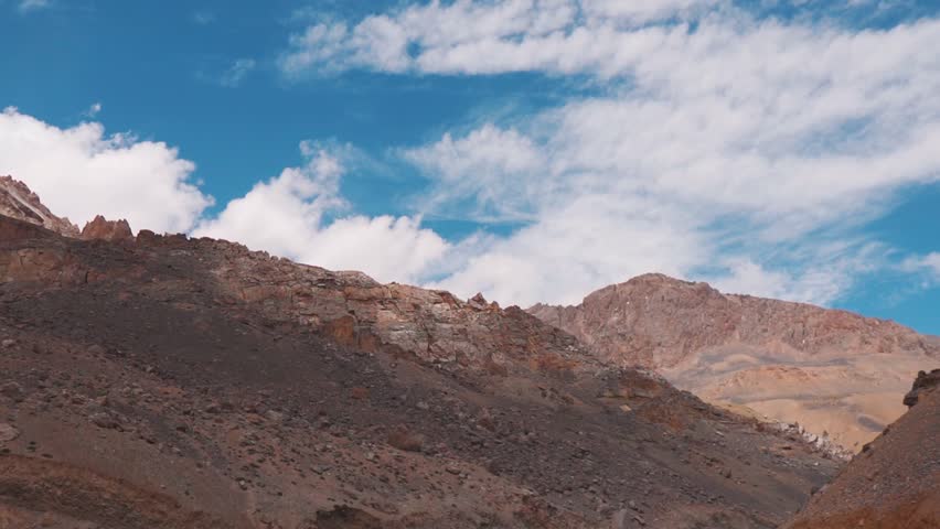 Landscape shot of clouds above the dry Himalayan mountain peaks of Ladakh as seen during the summer season at Leh Manali highway in India. Scenic view of clouds above the Himalayas in Ladakh. 