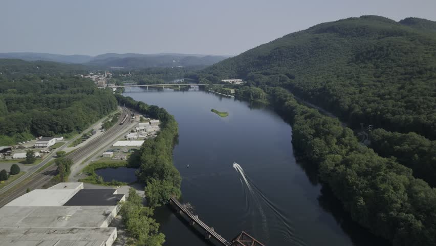 Drone lowers over Connecticut River next to metal bridge crossing border between Vermont and New Hampshire
