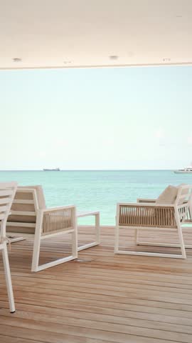 fixed plan from deck beach house overlooking tropical turquoise sea - cinematic vertical video