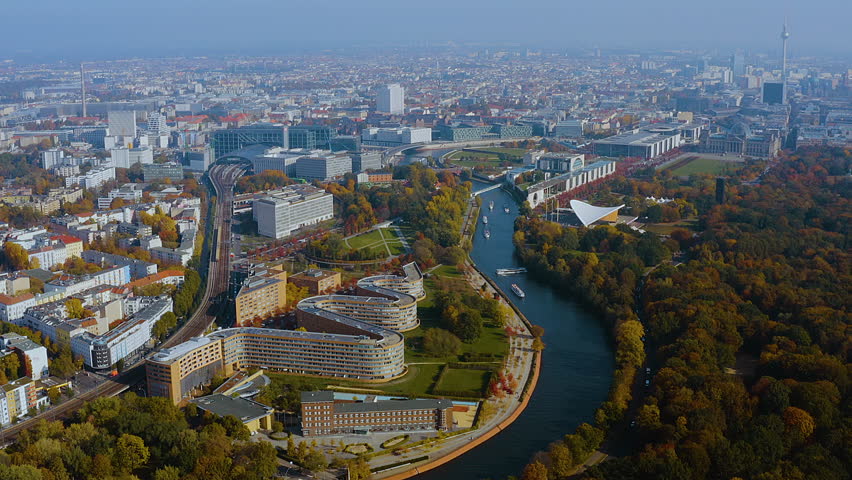 4K drone panorama of Berlin’s government quarter on the Spree : Hauptbahnhof, Chancellery, Reichstag dome - Haus der Kulturen der Welt framed by autumn Tiergarten and a skyline with the TV Tower.