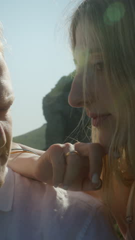 Close-up of a man gazing seriously at a woman against a scenic mountain background, suggesting tension or emotional conflict ,vertical video