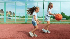 Sports Education. Full body length in action of children, little girl sisters playing basketball on a court, spending time outdoors - Powered by Shutterstock - Get 15% off with code: PIKWIZARD15
