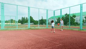 Sports Education. Full body length in action of children, little girl sisters playing basketball on a court, spending time outdoors - Powered by Shutterstock - Get 15% off with code: PIKWIZARD15