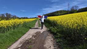 Man with French Flag in Blooming Canola Field.	 - Powered by Shutterstock - Get 15% off with code: PIKWIZARD15
