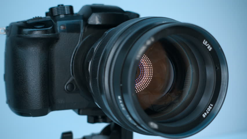 A professional camera on a tripod with an expensive lens with an aperture of 1.5 and a focal length of 85 mm, which reflects the ring LED light. Closeup. Macro