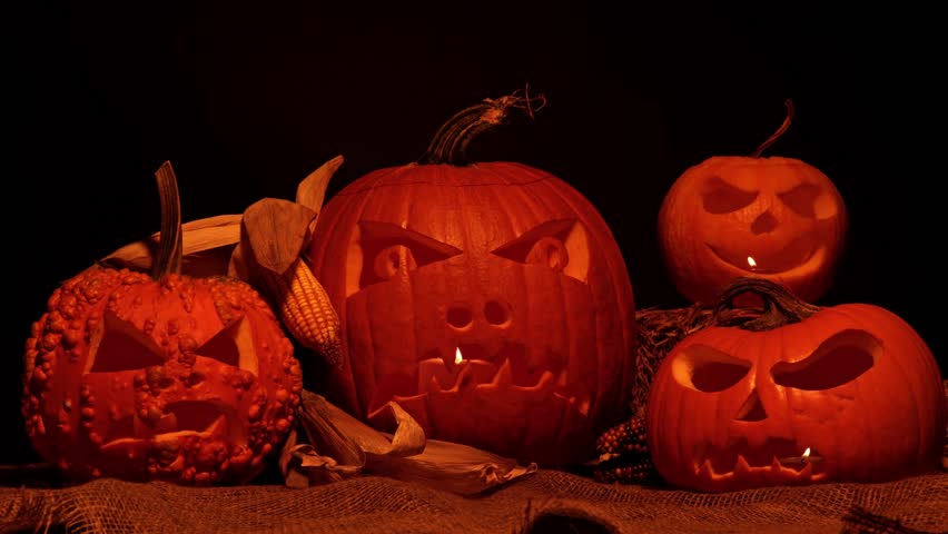 Halloween pumpkins dark arrangement for welcome celebration front yard decoration. All Saints day spirits Infernal and mystical background, burning flickering candles in the carved heads. - Powered by Shutterstock - Get 15% off with code: PIKWIZARD15
