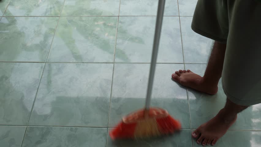 a man sweeping on a ceramic floor video asset, 4k video, quality