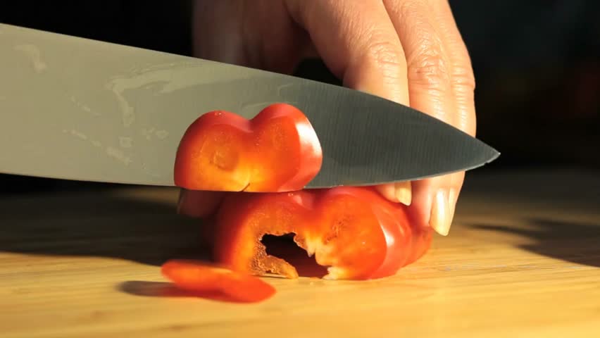 Close-up video of fresh vegetables being chopped on wooden cutting board. Includes carrots, cucumbers, tomatoes, and leafy greens. Perfect for cooking tutorials, healthy eating, and food prep content.