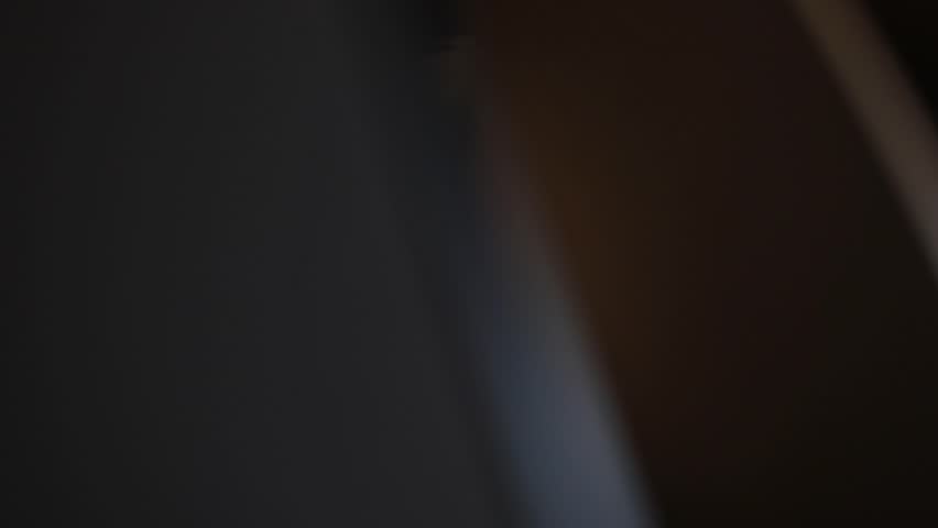 Close-up of a vintage film reel spinning, bathed in a warm, orange glow with beautiful light flares. Evokes nostalgia for classic cinema and movie projection. Perfect for film history, entertainment.