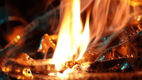 Close-up of vintage film strips engulfed in bright, mesmerizing flames and smoke. The melting celluloid symbolizes the end of an era, film loss, and destructive processes. - Powered by Shutterstock - Get 15% off with code: PIKWIZARD15