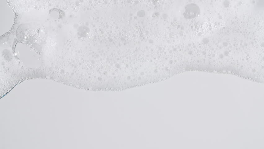 Texture of white soap foam with bubbles abstract background. Soap sud macro structure. Bathtup Soap Foam. Natural White Shampoo Bubbles Motion.