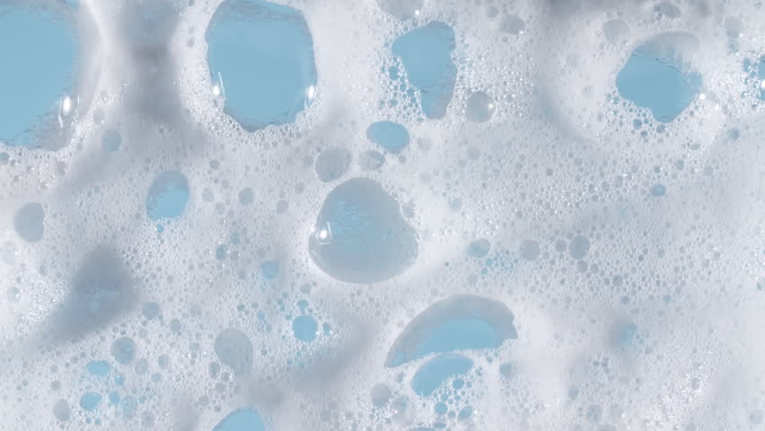 Texture of white soap foam with bubbles abstract background. Soap sud macro structure. Bathtup Soap Foam. Natural White Shampoo Bubbles Motion.