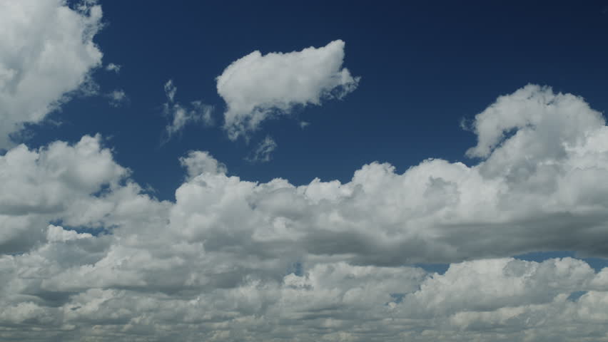 Beautiful cumulus clouds on a blue sky - time lapse video; slow movement of white clouds across the sky on a sunny day.
