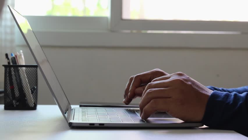 Businessman using laptop and mobile phone to enter password for two-factor authentication. Cybersecurity, privacy protection, secure login, identity verification, and online banking or digital payment