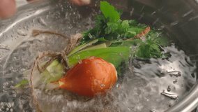 Slow motion close-up. A whole raw onion drops and splashes into a pot of boiling water next to a bouquet garni. Creating a base for a flavorful soup or stock - Powered by Shutterstock - Get 15% off with code: PIKWIZARD15