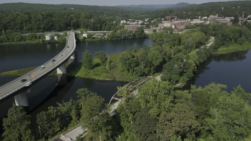 Drone orbits to the left over Hinsdale Bridge and General John Stark Bridge on the Connecticut River between Vermont and New Hampshire