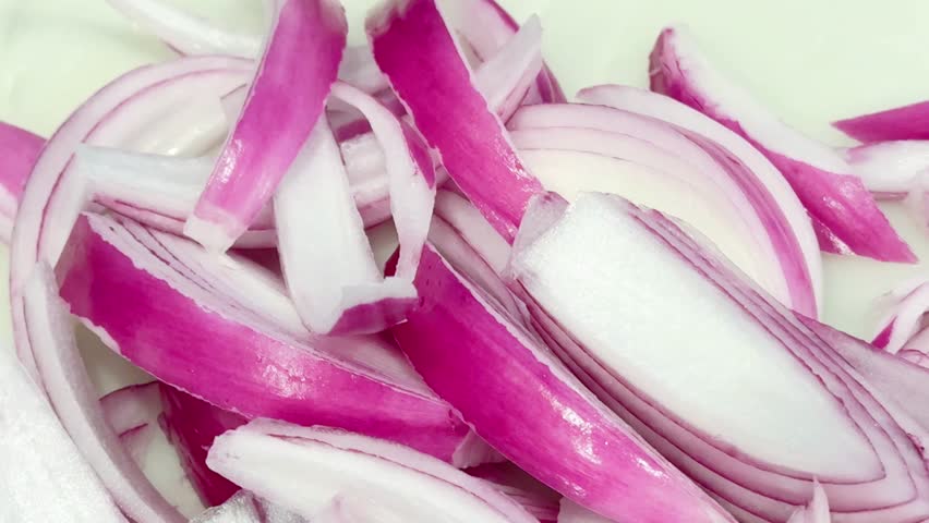 Sliced Raw Red Onions, on a Cutting Board. 