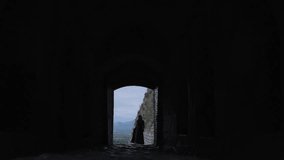 Woman's silhouette in a dark stone archway of Rozafa Castle Albania, slow motion - Powered by Shutterstock - Get 15% off with code: PIKWIZARD15