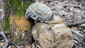 War in Ukraine: Gear of a foreign volunteer soldier during a pause in a tactical training drill. A helmet with a US flag patch and a backpack lie ready in a forest. - Powered by Shutterstock - Get 15% off with code: PIKWIZARD15