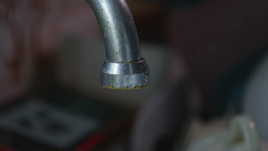 Close-up of water flowing from Kitchen tap from gush, trickle, to drips