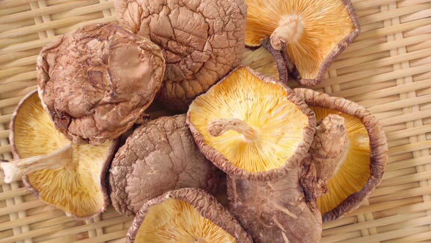 Dried Shiitake Mushrooms on Bamboo Sieve with Wooden Background