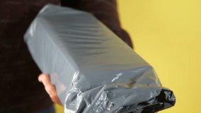 Unboxing a mystery package at home in bright yellow background - Powered by Shutterstock - Get 15% off with code: PIKWIZARD15