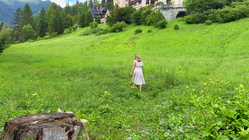 Woman in dress exploring castle of Peles in the rural Transylvania, Romania