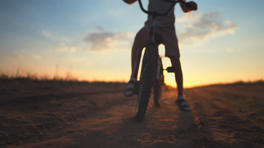 Happy childhood moments, little boy riding bicycle, closeup view of front wheel. Sport activity and children games in weekend or vacation in summertime, ride bike in nature, spinning pedals, details