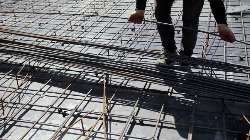 Worker placing steel reinforcement bars at construction site - Powered by Shutterstock - Get 15% off with code: PIKWIZARD15