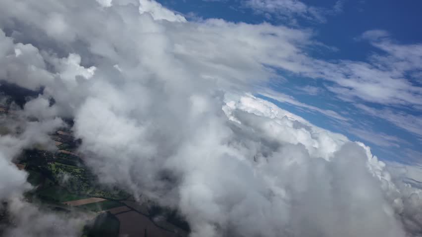 POV flying free through some cottony clouds doing a left turn under a deep blue sky. Aerial shot taken from a jet cockpit. ultra-realistic 4K