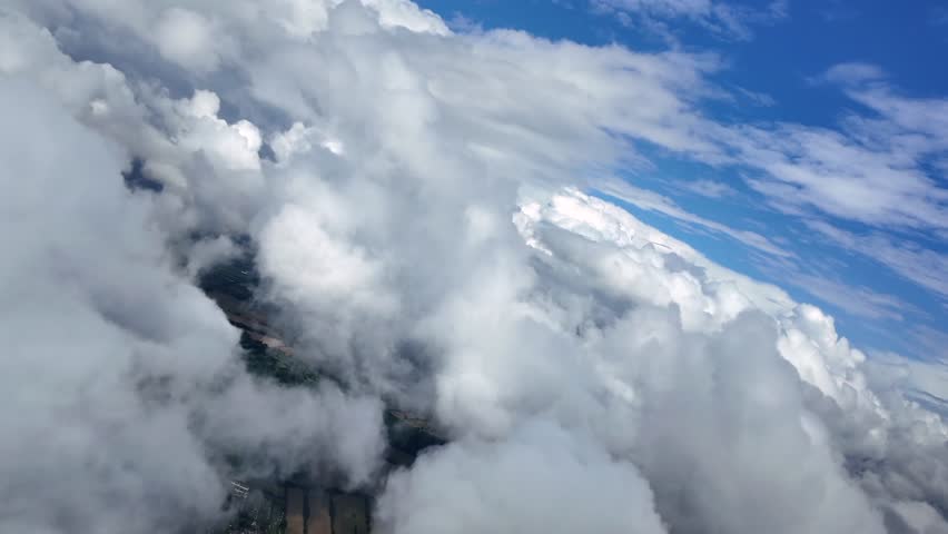 An immersive pilot’s view flying freely through some cottony stratocumulus clouds under an intense color blue sky. Shot taken from a jet cockpit. ultra-realistic 4K.