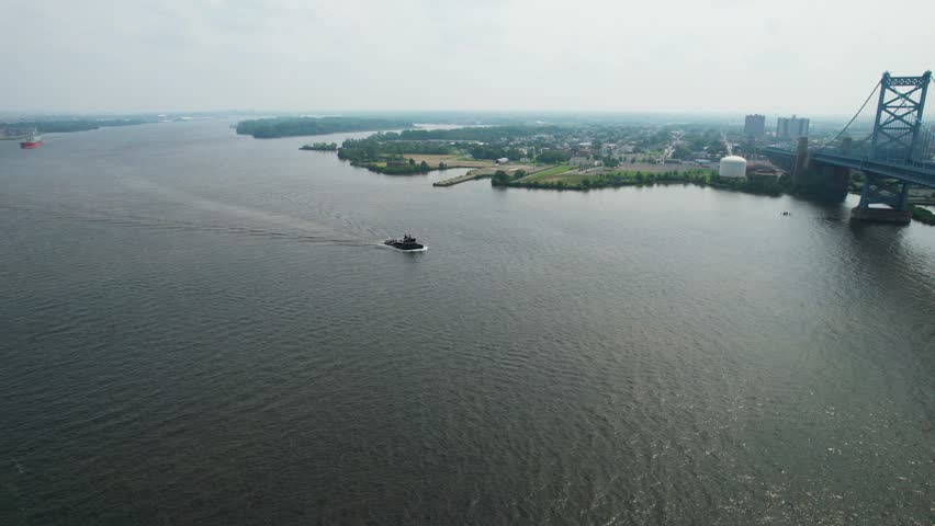 descending drone shot of a tug boat on Delaware river summer morning