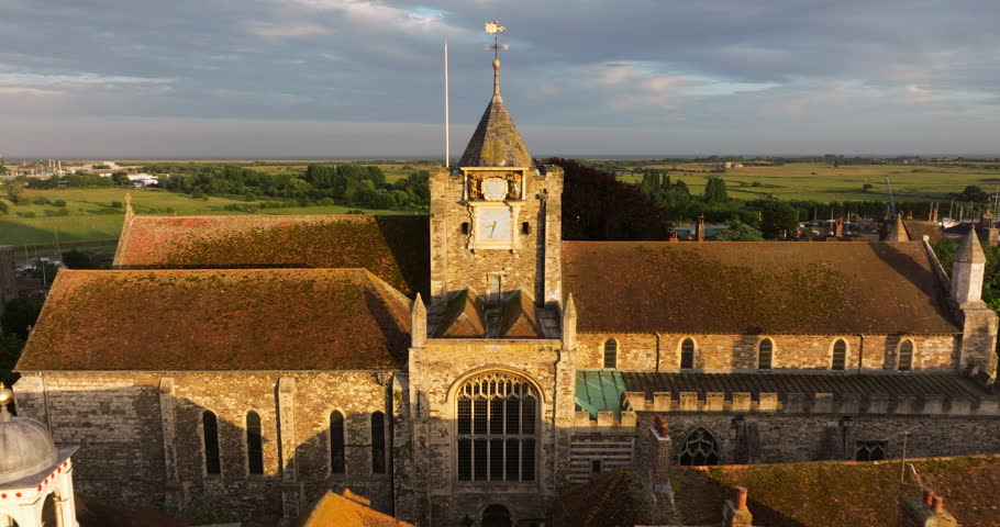 Exterior View Of Saint Mary Church With Birds Flying Over The Town At Dusk In England, UK. - aerial pullback shot