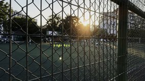 Children Practicing Football Behind a Wire Fence at Sunset Light - Powered by Shutterstock - Get 15% off with code: PIKWIZARD15