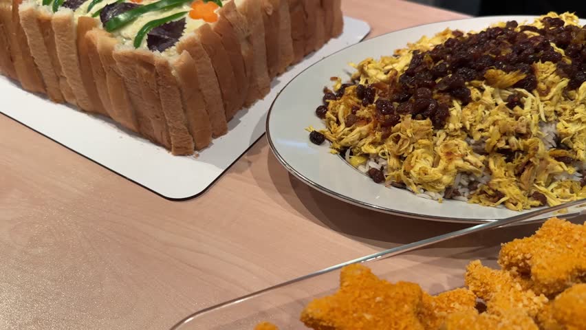 Iranian party table with adas polo cooking sandwich cake chicken nuggets and gourmet appetizers Lentil rice with saffron raisins salad and homemade sauces Perfect dining for family cuisine gatherings