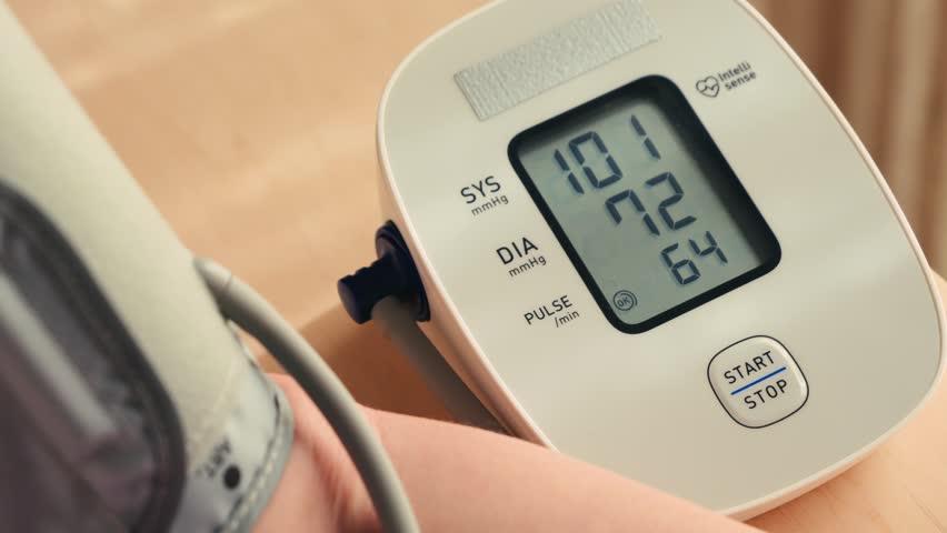 Female hand using automatic tonometer for blood pressure checking. High quality 4k footage