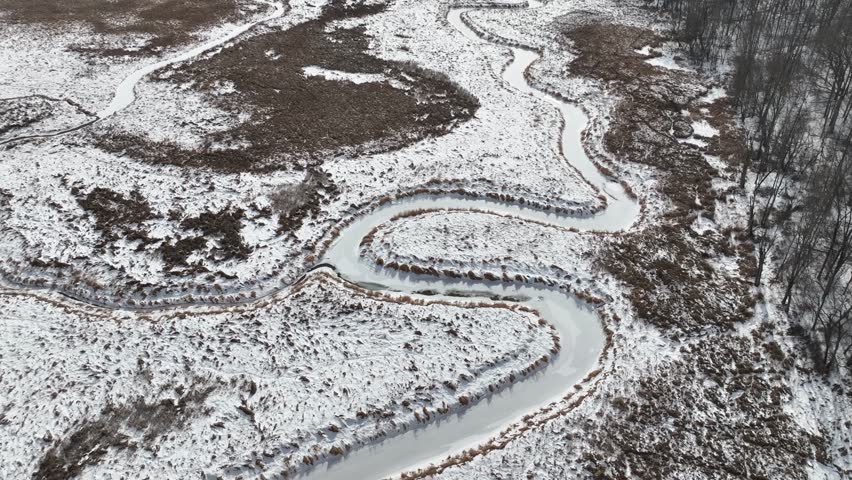 Frozen wetland marsh in winter freeze natural flowing creek Hemlock Finger Lake New York Glacier lake with wetlands