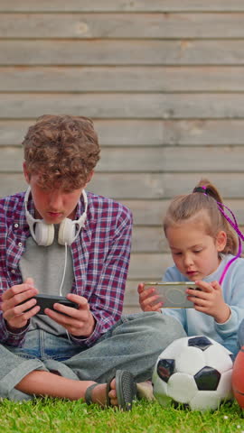 Children using smartphone together outdoor. Smartphone addiction