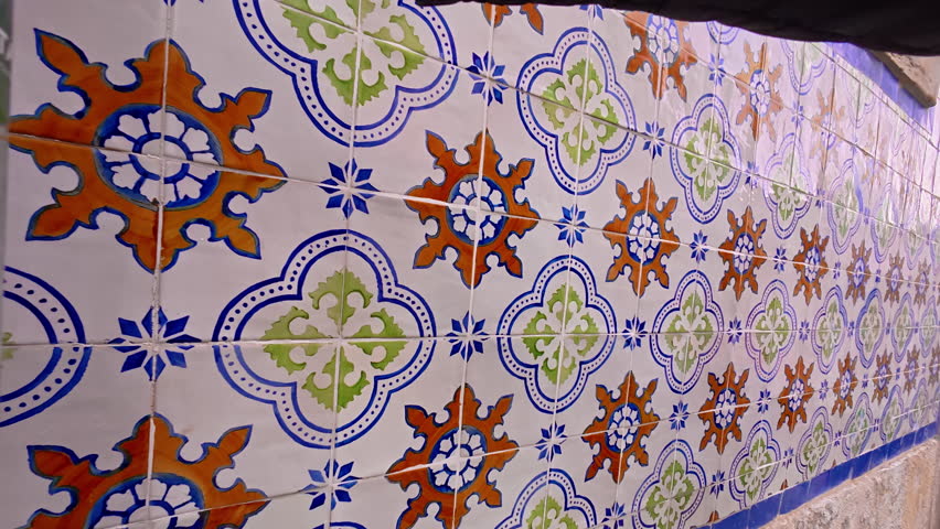 Traditional glazed tile azulejos on the facade of the house in Lisbon, Portugal. The girl runs her hand over the tiles