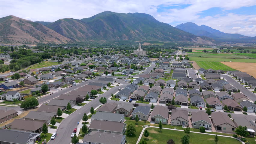 Aerial footage beautifully captures a tranquil residential community in Salt Lake City that is nestled among majestic mountains, stunning and visually appealing landscape that is pleasing to the eye