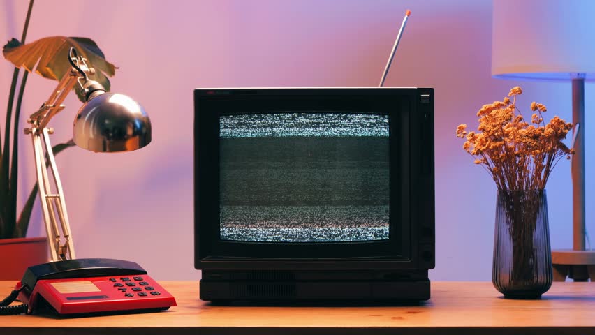 Retro TV, vintage television In a nostalgic setup, a retro TV displays grain on screen, scary halloween night device good for chroma key and green screen.