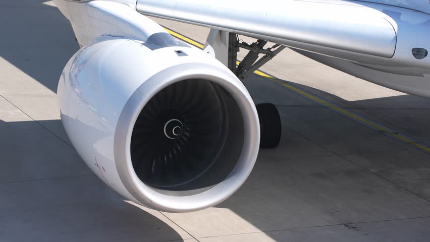 Close-up of jet engine of passenger airplane slowing down with smoke at Swiss Airport Zürich Kloten on a hot summer day. Movie shot August 11th, 2025, Zurich Kloten, Switzerland.