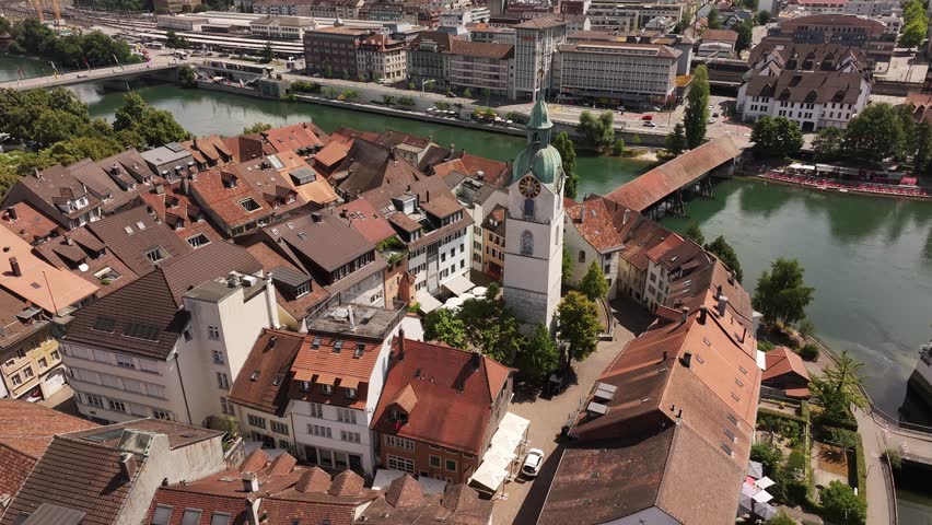 aerial - red tiled roofs circle clocktower and wooden bridge in olten solothurn switzerland