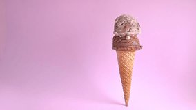 standing wafer cone with chocolate and chocolate chips scoops of ice cream decorated with strewed sprinkles on pink background, copy space, slow motion - Powered by Shutterstock - Get 15% off with code: PIKWIZARD15