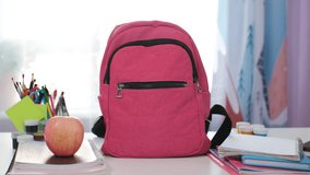 Teen girl is focused on packing her schoolbag with colorful supplies while sticking a bright note that reads Back to School on her pink backpack - Powered by Shutterstock - Get 15% off with code: PIKWIZARD15