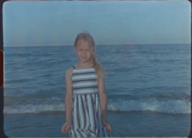 Close up zoom of girl showing colorful painted nails and smiling on retro super 8mm vintage film