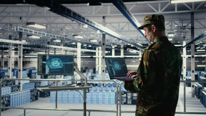 Soldier in engineering role uses AI application on laptop to manage server hub systems. Army commander reviews secret intelligence information using artificial intelligence in data center, camera A - Powered by Shutterstock - Get 15% off with code: PIKWIZARD15